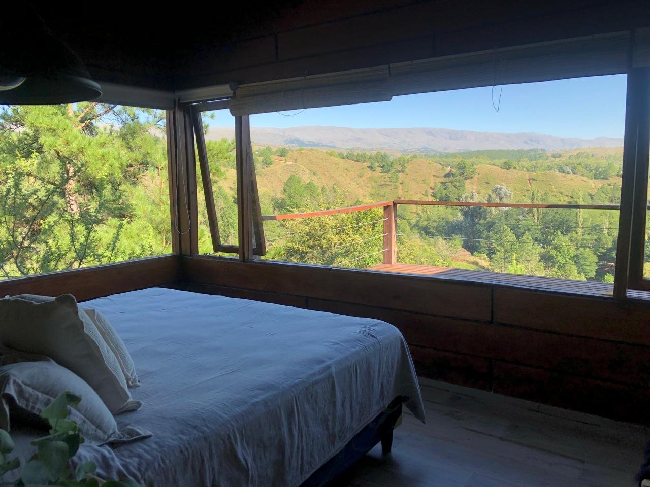 Dormitorio con ventanal panorámico a las sierras